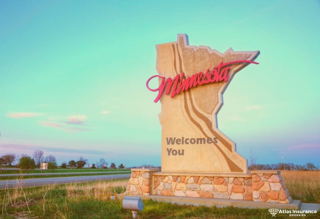 Minnesota welcome sign along a highway, symbolizing small businesses across the state. Atlas Insurance Brokers logo in the bottom right corner.